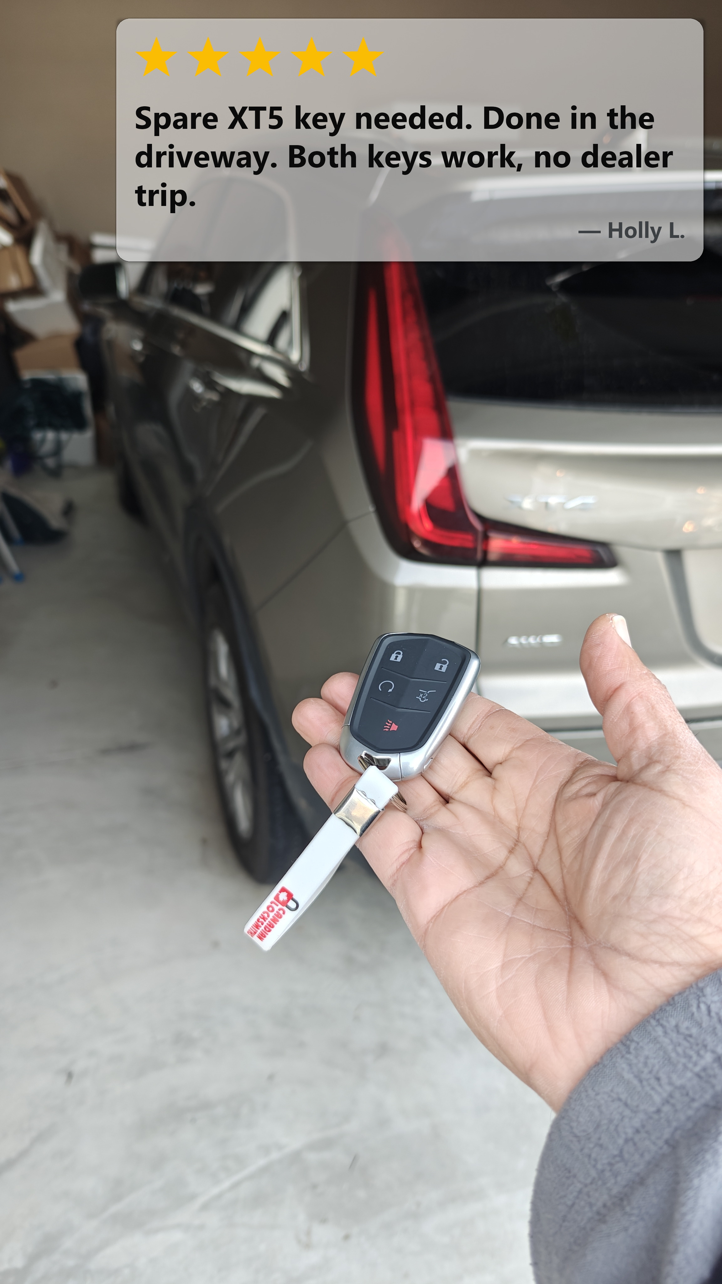 New Cadillac XT5 spare smart key held in a customer's garage near the Walmart Supercentre corridor in South Windsor, with five-star review card
